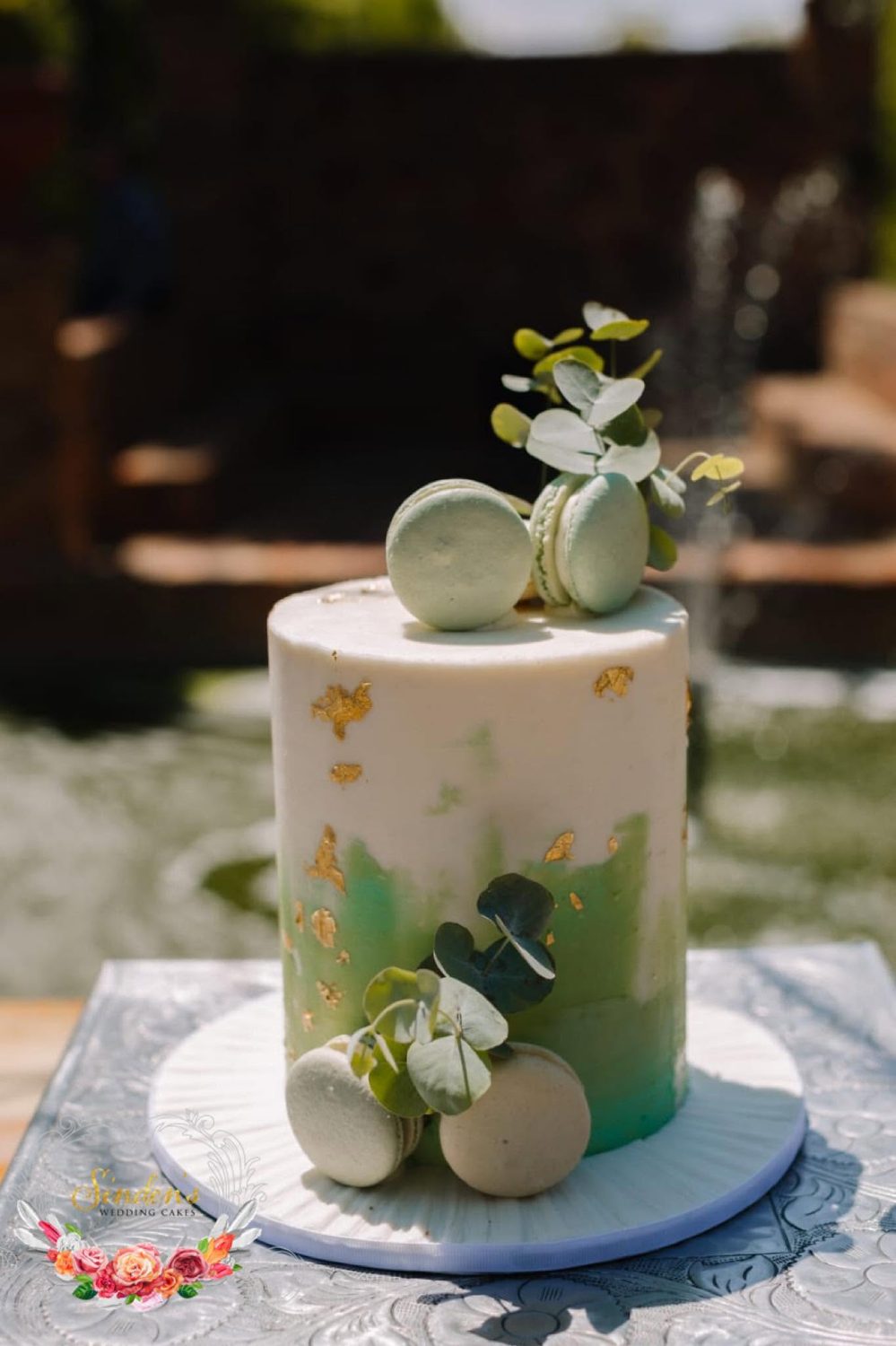 White cake with greenery and small florals
