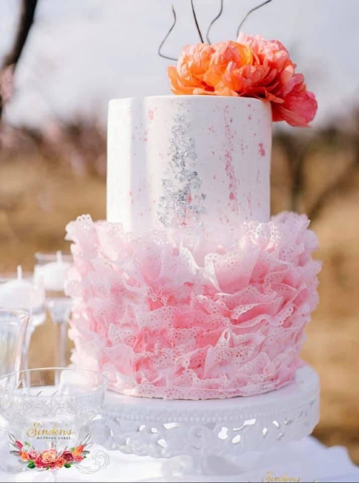 Blush ombre ruffle cake in a field