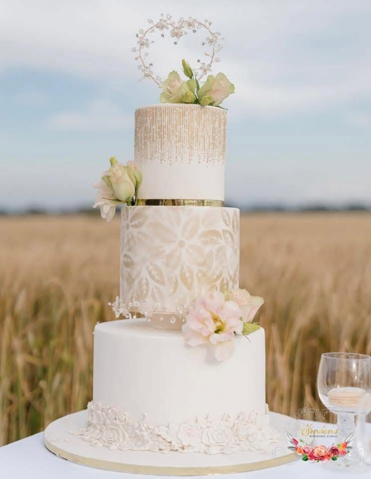 White cake with greenery in a wheatfield setting